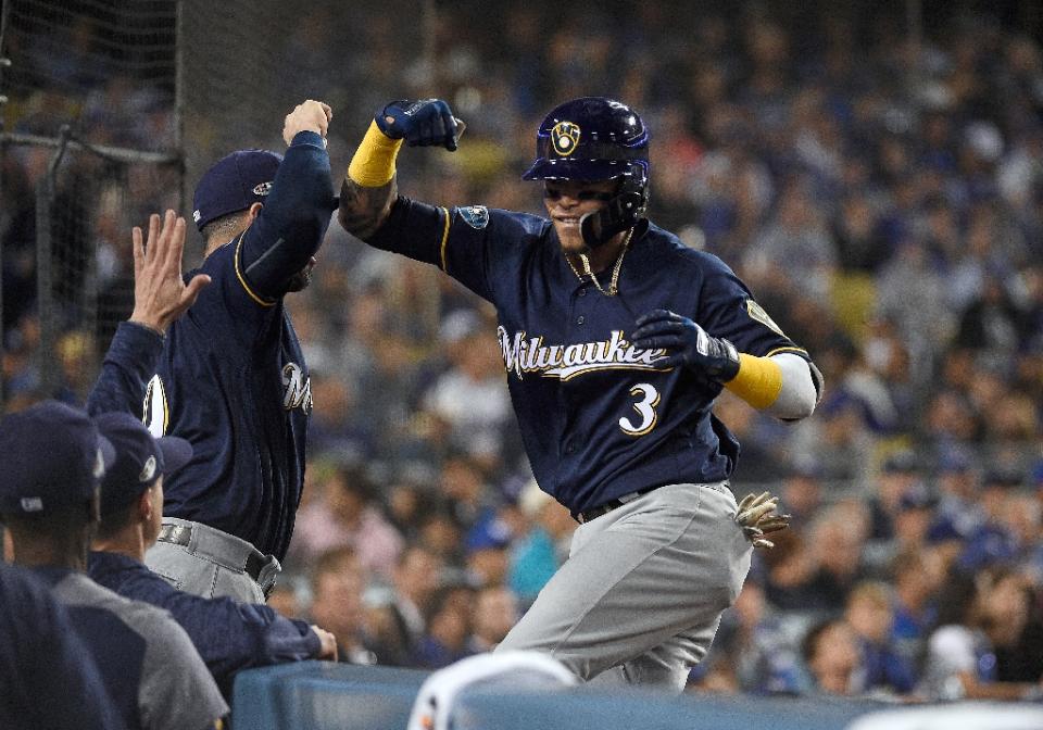 Milwaukee's Orlando Arcia celebrates with teammate Mike Moustakas after hitting a two-run homer in the Brewers' victory in Game 3 of the NLCS. (AP)