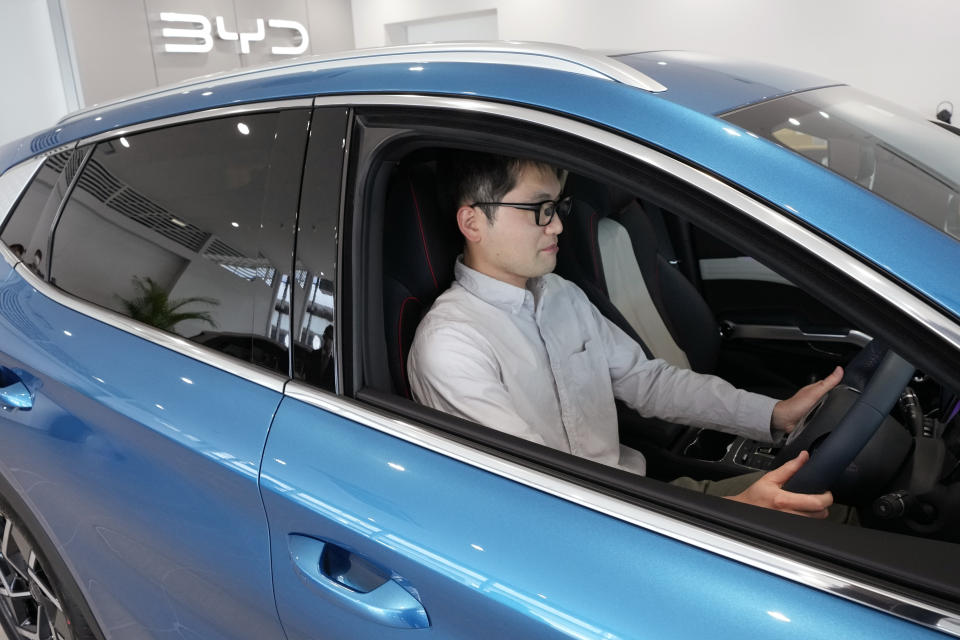 Ohta, who just bought a brand new BYD ATTO 3 electric sports utility vehicle, sits in his car at a BYD dealership on April 4, 2023, in Yokohama near Tokyo. BYD Auto is part of a wave of Chinese electric car exporters that are starting to compete with Western and Japanese brands in their home markets. They bring fast-developing technology and low prices that Tesla Inc.'s chief financial officer says “are scary.” (AP Photo/Eugene Hoshiko)