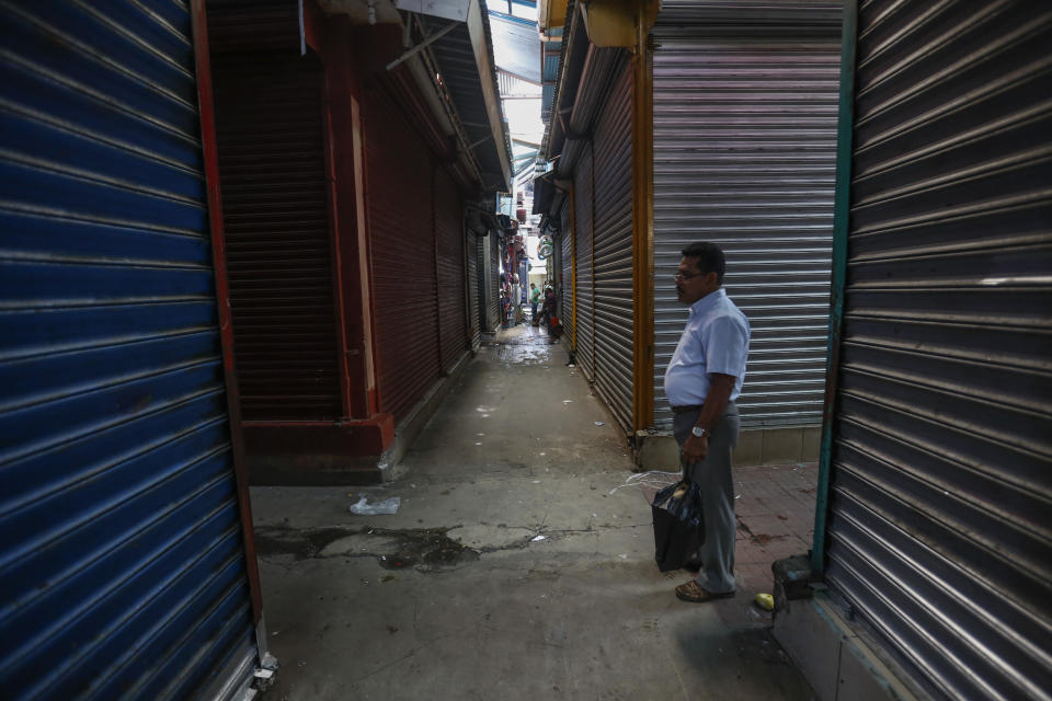 En esta imagen, tomada el 7 de septiembre de 2018, un hombre camina entre las persianas cerradas de los puestos del Mercado Oriental durante un huelga general de 24 horas, en Managua, Nicaragua. En junio, la actividad económica del país había caído un 12,1% en comparación con el año anterior, según el Banco Central. (AP Foto/Alfredo Zúñiga)