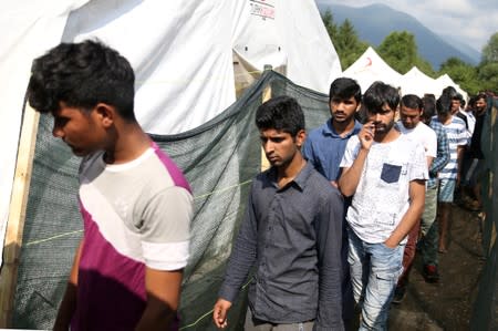 FILE PHOTO: Migrants wait for breakfast in camp Vucjak in Bihac