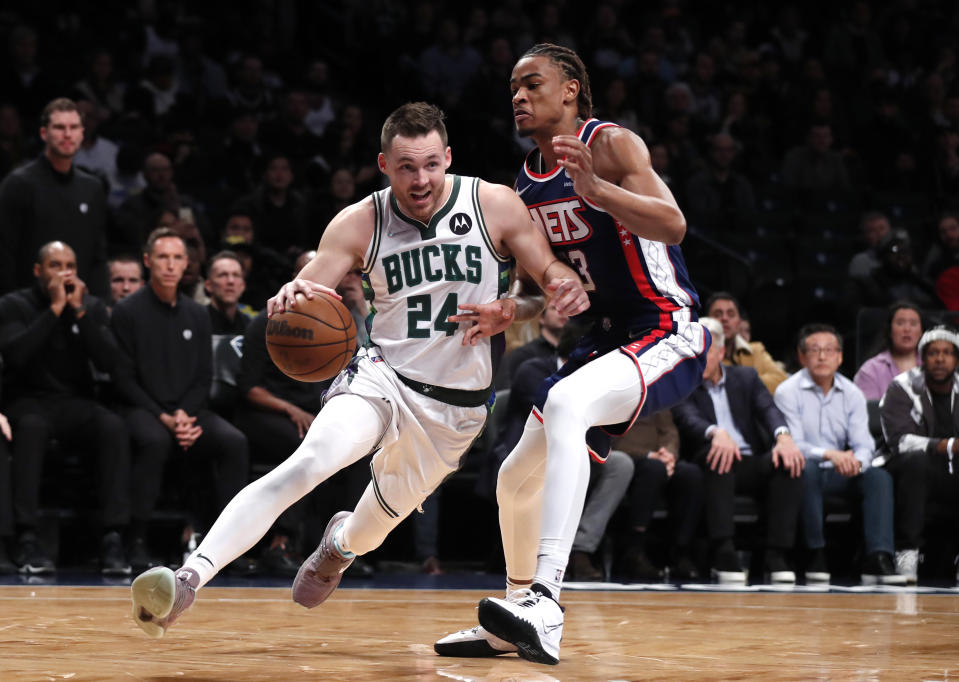 Milwaukee Bucks guard Pat Connaughton (24) drives to the basket against Brooklyn Nets forward Nic Claxton (33) during the first half of an NBA basketball game Thursday, March 31, 2022, in New York. (AP Photo/Noah K. Murray)