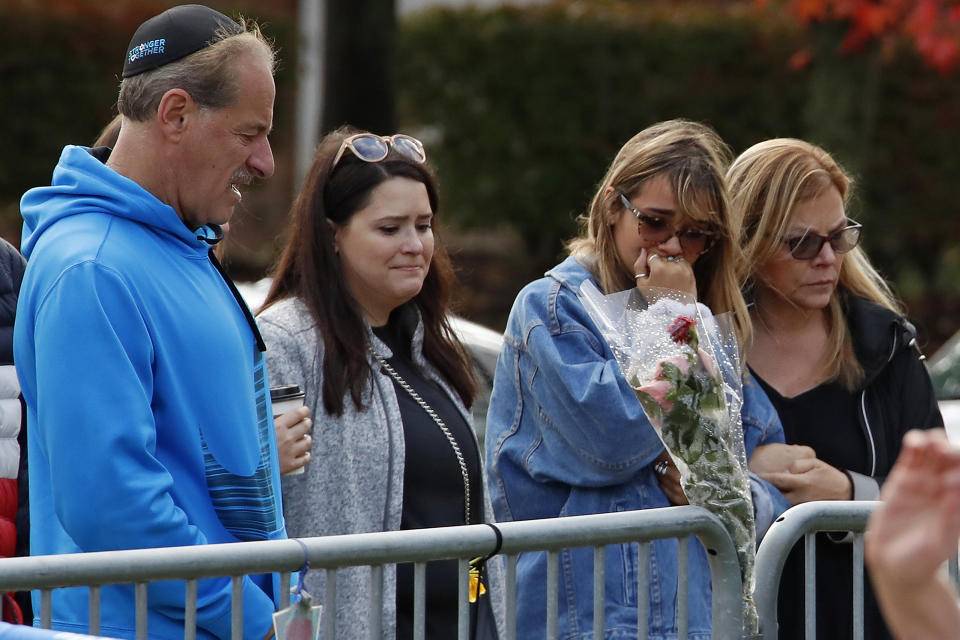 People gather in front of a fence that surrounds the Tree of Life synagogue in Pittsburgh on Sunday, Oct. 27, 2019, the first anniversary of the shooting at the synagogue, that killed 11 worshippers. (AP Photo/Gene J. Puskar)
