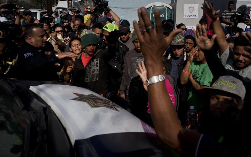 Immigrants argue with the police after they detained two men for smoking marijuana, in Tijuana, Mexico, Wednesday, Nov. 21, 2018. Migrants camped in Tijuana after traveling in a caravan reach the US are weighing their options after a US court blocked President Donald Trump’s asylum for illegal border crossers. (AP Photo / Ramon Espinosa)