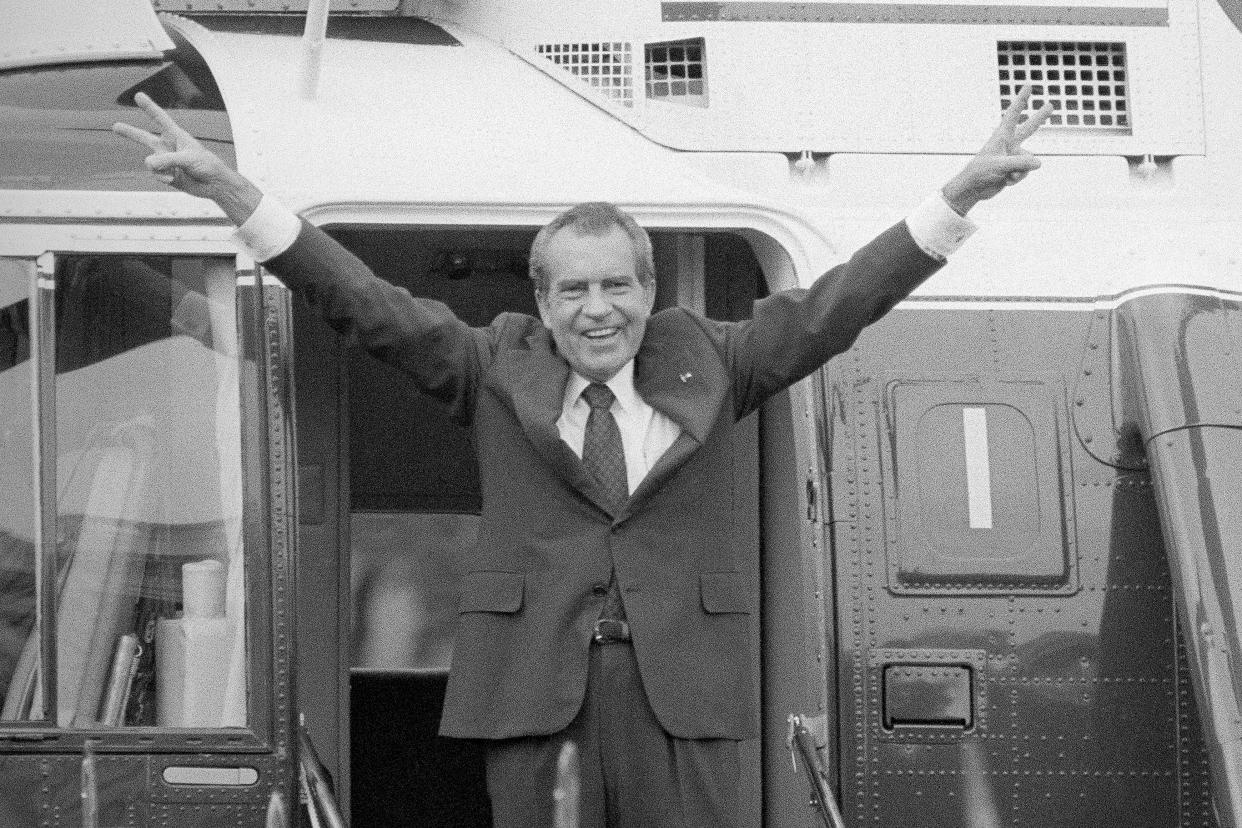 FILE - Richard Nixon says goodbye with a victorious salute to his staff members outside the White House as he boards a helicopter after resigning the presidency on Aug. 9, 1974. Nixon resigned from office rather than face impeachment for his administration’s coverup of its involvement in a break-in at the Democratic National Committee headquarters in Washington. (AP Photo/Bob Daugherty, File)