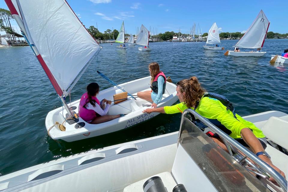 Sailing instructor Olin Wolfgram helps Ella Campbell (left) and Alayna Iversen with their boat as they learn the fine art of sailing during an Emerald Coast Sailing Association summer camp.