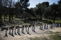 Actresses, playing the role of priestesses, performance during the flame lighting ceremony at the closed Ancient Olympia site, birthplace of the ancient Olympics in southern Greece, Thursday, March 12, 2020, 2020. Greek Olympic officials are holding a pared-down flame-lighting ceremony for the Tokyo Games due to concerns over the spread of the coronavirus. Both Wednesday's dress rehearsal and Thursday's lighting ceremony are closed to the public, while organizers have slashed the number of officials from the International Olympic Committee and the Tokyo Organizing Committee, as well as journalists at the flame-lighting. (AP Photo/Thanassis Stavrakis)