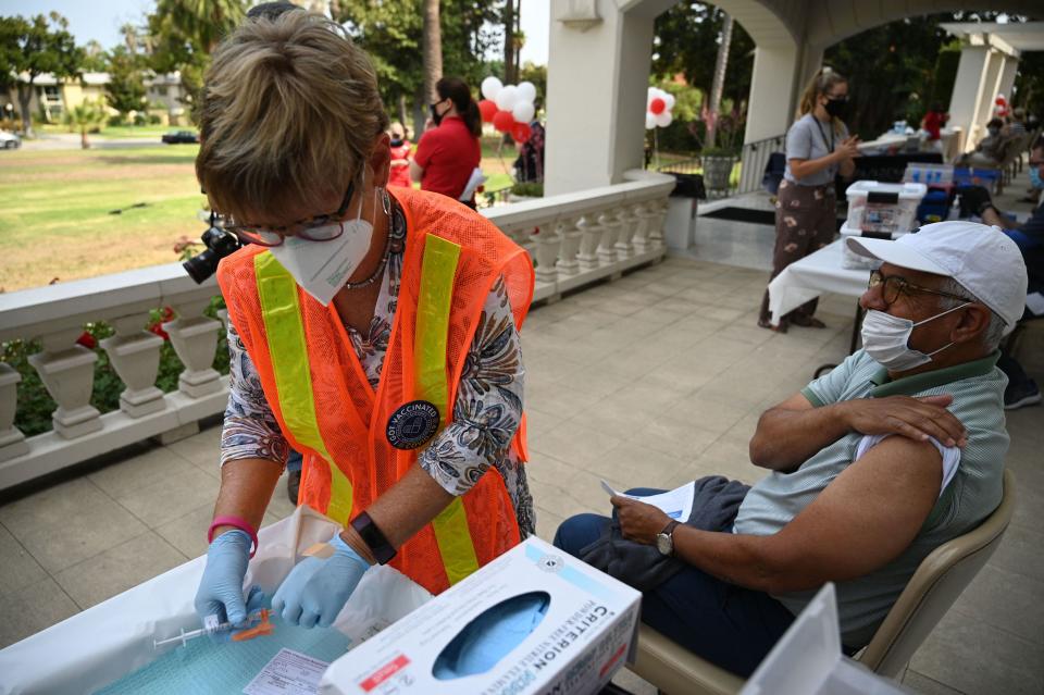 A nurse prepares a Pfizer Covid-19 vaccine for Jose Luis Sanchez at a clinic on August 19, 2021 at Tournament House in Pasadena, California. (Photo by Robyn Beck / AFP)