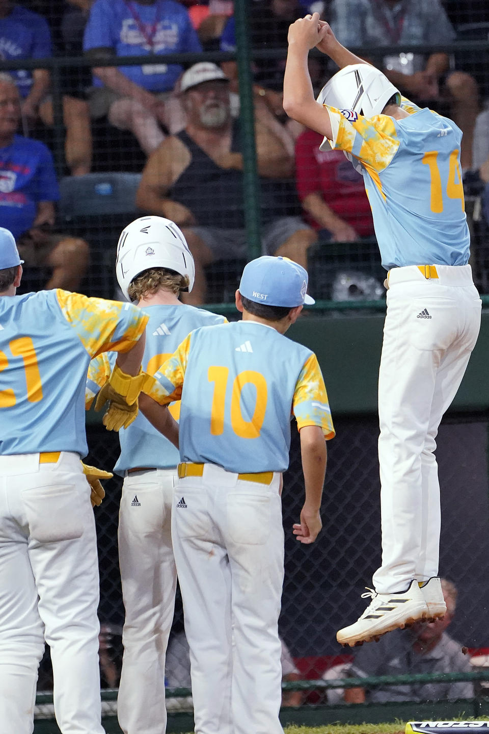 El Segundo, Calif.'s Brody Brooks (14) leaps onto home plate after his two-run home run off New Albany, Ohio's Kevin Klingerman during the third inning of a baseball game at the Little League World Series tournament in South Williamsport, Pa., Thursday, Aug. 17, 2023. (AP Photo/Tom E. Puskar)