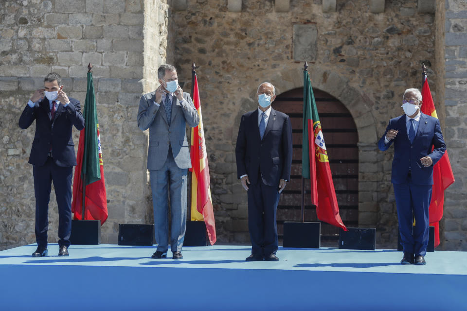 From left to right: Spain's Prime Minister Pedro Sanchez, Spain's King Felipe VI, Portugal's President Marcelo Rebelo de Sousa and Portugal's Prime Minister Antonio Costa adjust their face masks during a ceremony to mark the reopening of the Portugal/Spain border in Elvas, Portugal, Wednesday, July 1, 2020. The border was closed for three and a half months due to the coronavirus pandemic. (AP Photo/Armando Franca)