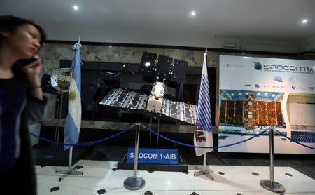 A woman walks past a scaled-down replica of the SAOCOM 1-A/B satelite on display at Argentina's space agency CONAE in Buenos Aires, Argentina September 20, 2018. REUTERS/Marcos Brindicci