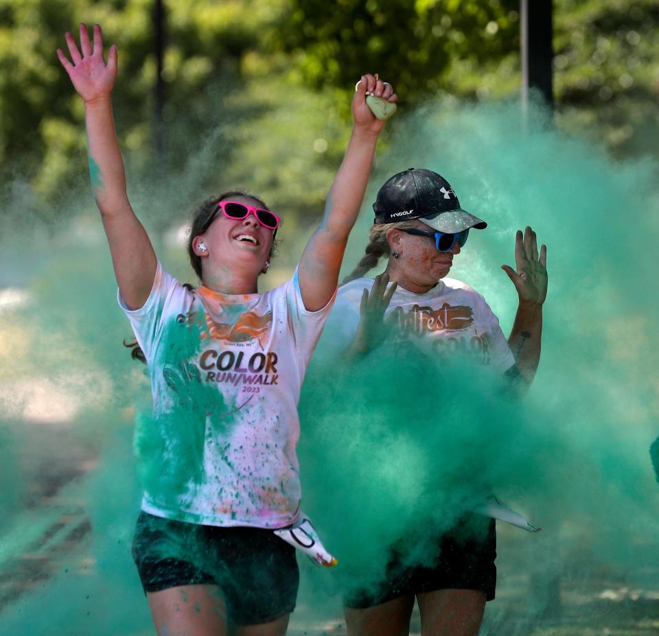 Runners and walkers participate in the ArtFest Color Run/Walk on July 29, 2023, in downtown Green Bay, Wis. About 200 participants were covered with different colored powders at stations along the 2½-mile route.