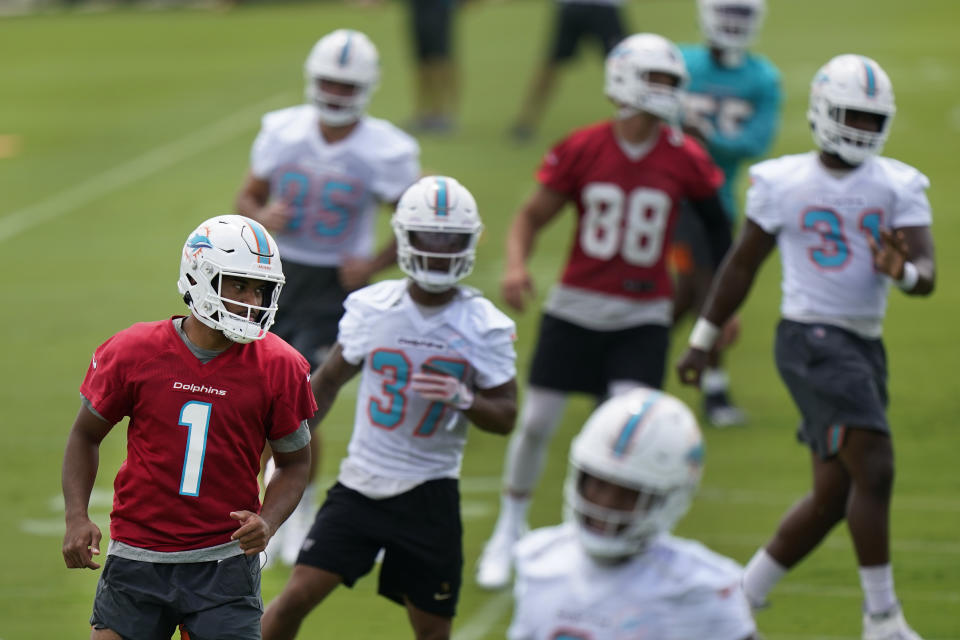 Miami Dolphins quarterback Tua Tagovailoa (1) warms up with teammates during a mandatory minicamp at the NFL football team's training camp, Tuesday, June 15, 2021, in Davie, Fla. (AP Photo/Wilfredo Lee)