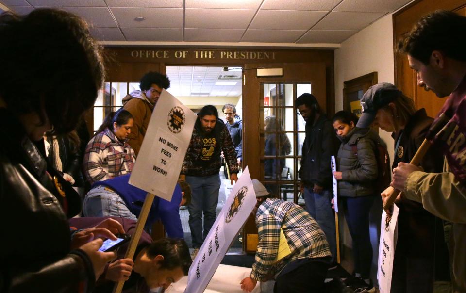 Members of COGS UE Local 896, representing University of Iowa graduate student workers, carry a petition to University President Barbara Wilson’s office while protesting graduate student fees Tuesday, March 5, 2024 on the University of Iowa campus in Iowa City, Iowa.