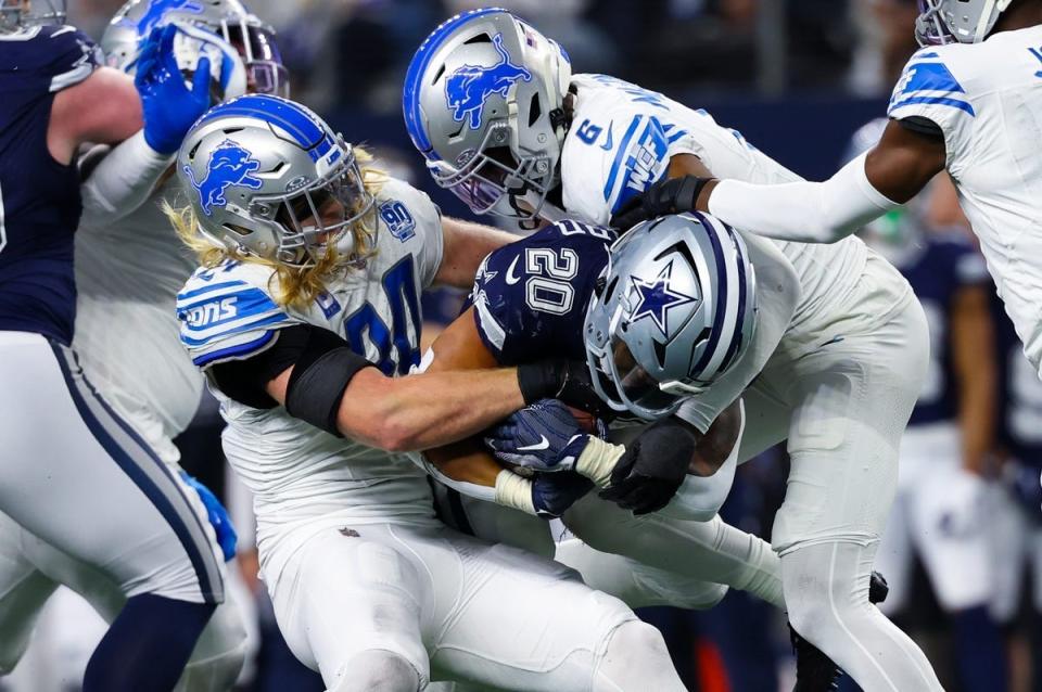 Dec 30, 2023; Arlington, Texas, USA; Dallas Cowboys running back Tony Pollard (20) is tackled by Detroit Lions linebacker Alex Anzalone (34) and Detroit Lions safety Ifeatu Melifonwu (6) during the second half at AT&T Stadium. Mandatory Credit: Kevin Jairaj-USA TODAY Sports