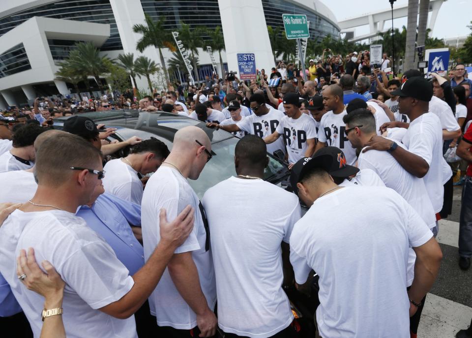 <p>Somber Miami Marlins players and staff surround a hearse carrying the body of pitcher Jose Fernandez as it leaves Marlins Park stadium, Wednesday, Sept. 28, 2016, in Miami. Fernandez, was killed in a weekend boat crash along with two friends. (AP Photo/Wilfredo Lee) </p>