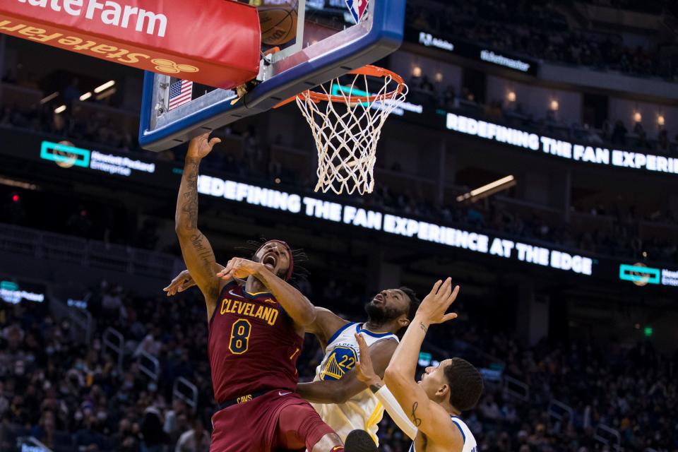 Cleveland Cavaliers forward Lamar Stevens (8) lays up the ball in front of Golden State Warriors forward Andrew Wiggins (22) and forward Juan Toscano-Anderson, right, during the first half of an NBA basketball game in San Francisco, Sunday, Jan. 9, 2022. (AP Photo/John Hefti)