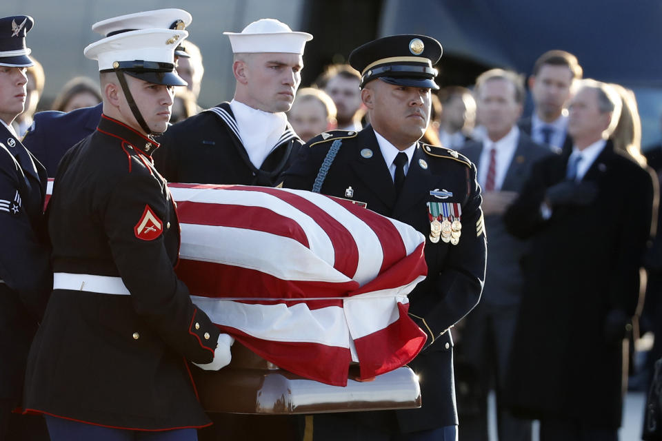 The flag-draped casket of former President George H.W. Bush is carried by a joint services military honor guard to the hearse, Monday, Dec. 3, 2018, at Andrews Air Force Base, Md. (AP Photo/Alex Brandon, Pool)