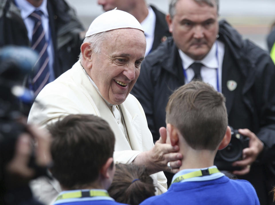 Pope Francis greets children as he disembarks from an airplane at Knock's airport, Ireland, where he will visit the Knock Shrine and recite an angelus prayer, Sunday, Aug. 26, 2018. Pope Francis is on a two-day visit to Ireland. (Yui Mok/PA via AP)