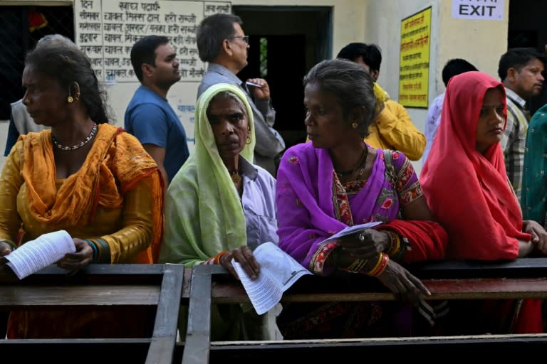 People stand in a queue to cast their votes at a polling station at Haridwar (Arun SANKAR)