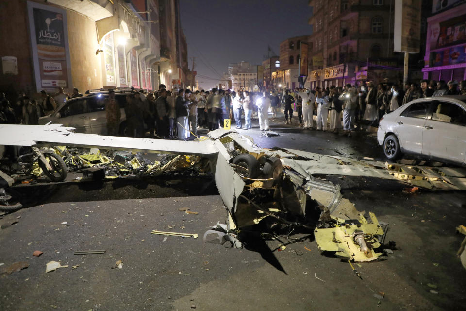 People gather around the wreckage of a drone aircraft which Houthi rebels claimed to have shot down, in Sanaa, Yemen, Monday, May 23, 2022. (AP Photo/Hani Mohammed)