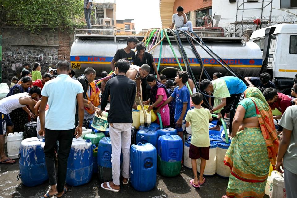 Residents fill their containers with water supplied by a municipal tanker in Delhi, India (AFP via Getty)