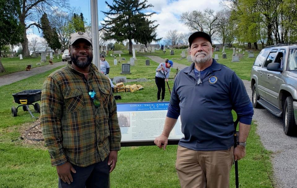 Jamaal Lampkin, left, and Director Daniel Devine from the National Cemetery Administration, a division of the U.S. Dept. of Veterans Affairs stands with the sign after the unveiling.