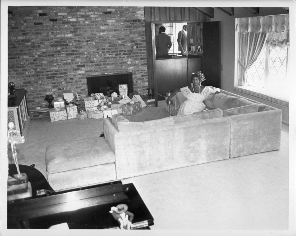 <p>The Queen of Soul lounges on the couch of her Detroit home, while keeping her eye on the hoard of Christmas presents displayed in front of her fireplace.</p>