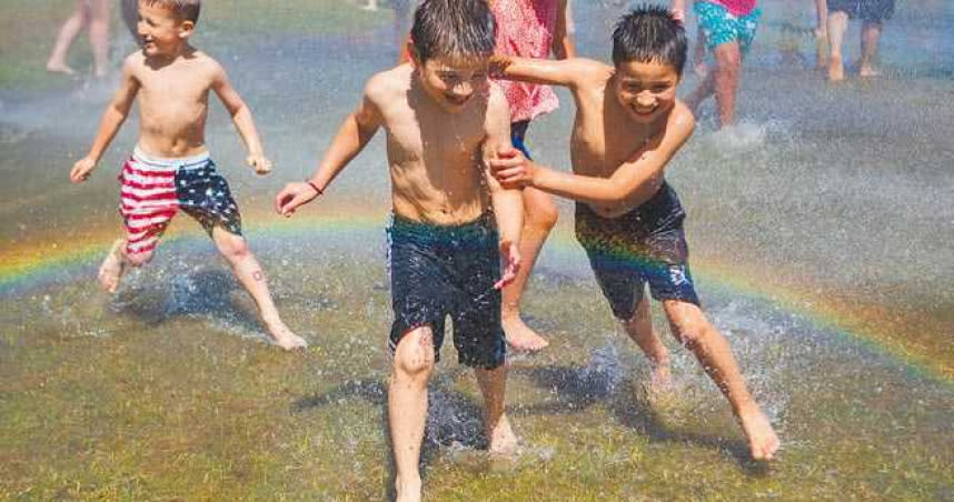 北美洲西北地區連日來遭遇熱浪侵襲。美國華盛頓州艾夫瑞特市消防隊利用消防灑水系統製造噴泉，供當地兒童玩水消暑。水花噴出時，還出現彩虹。（圖／美聯社）