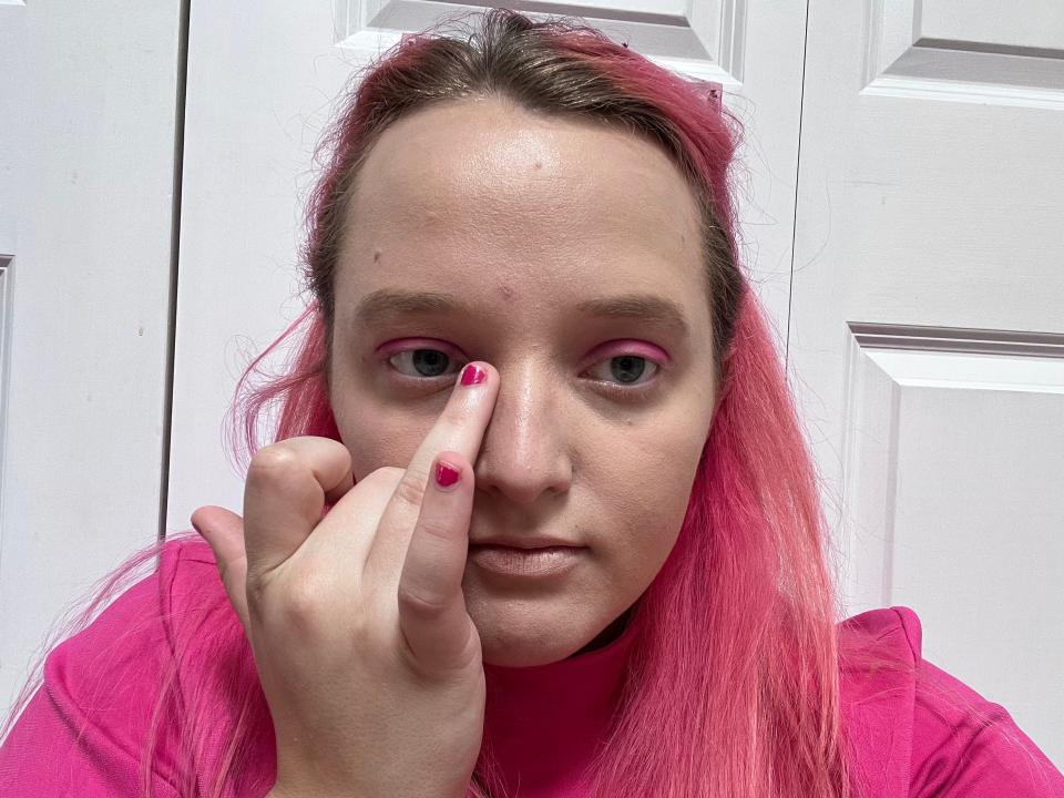 The writer applies pink glitter to her eyes