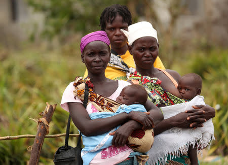 Women and children await medical treatment at a camp for people displaced in flooding in the aftermath of Cyclone Idai, near Beira, Mozambique, March 23, 2019. REUTERS/Mike Hutchings