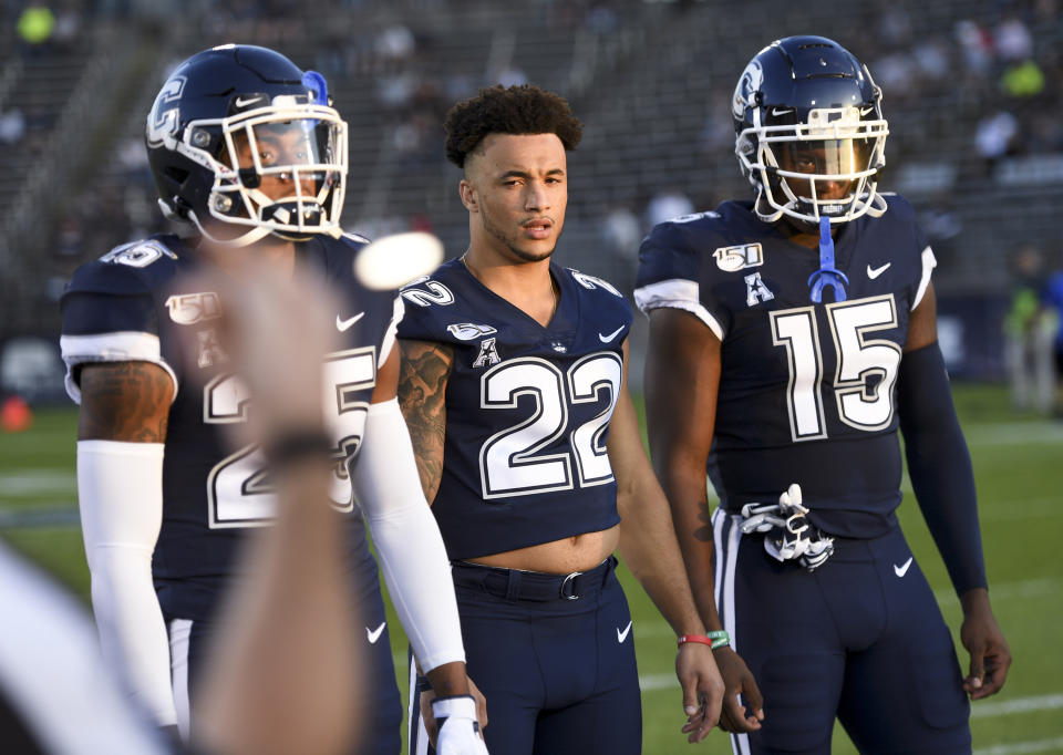 FILE - In this Aug. 29, 2019, file photo, Connecticut team captain Eli Thomas (22) takes part in the coin toss before an NCAA college football game against Wagner in East Hartford, Conn. Thomas, who overcame a stroke to return to school, is among the first six athletes named as finalists for the Hartford HealthCare Courage Award. (AP Photo/Stephen Dunn, File)
