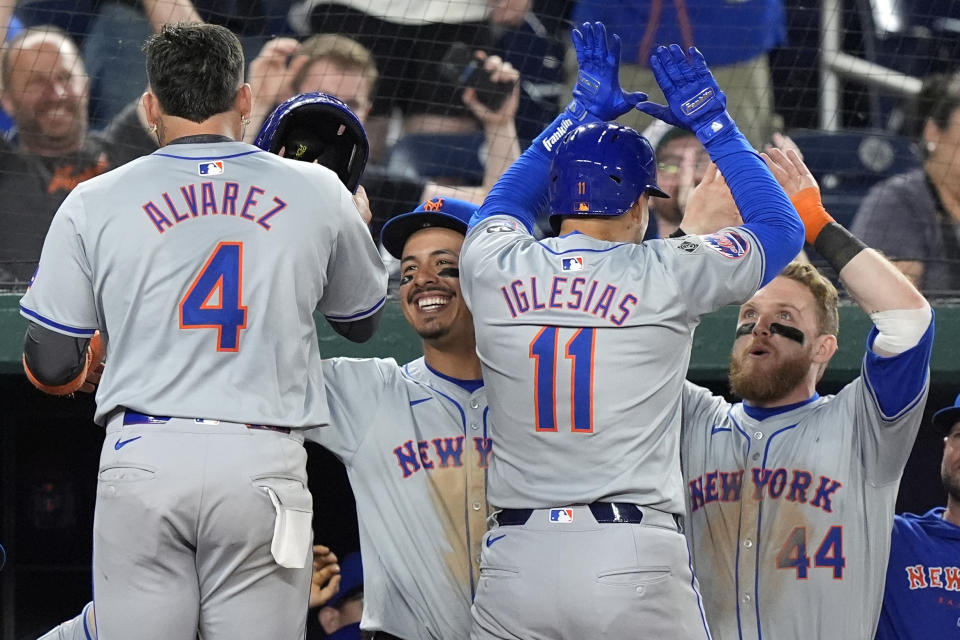 New York Mets' Mark Vientos, second from left, and Harrison Bader (44) celebrate with Francisco Alvarez (4) and Jose Iglesias (11) after Iglesias hit a two-run home run during the 10th inning of a baseball game at Nationals Park, Monday, July 1, 2024, in Washington. (AP Photo/Mark Schiefelbein)