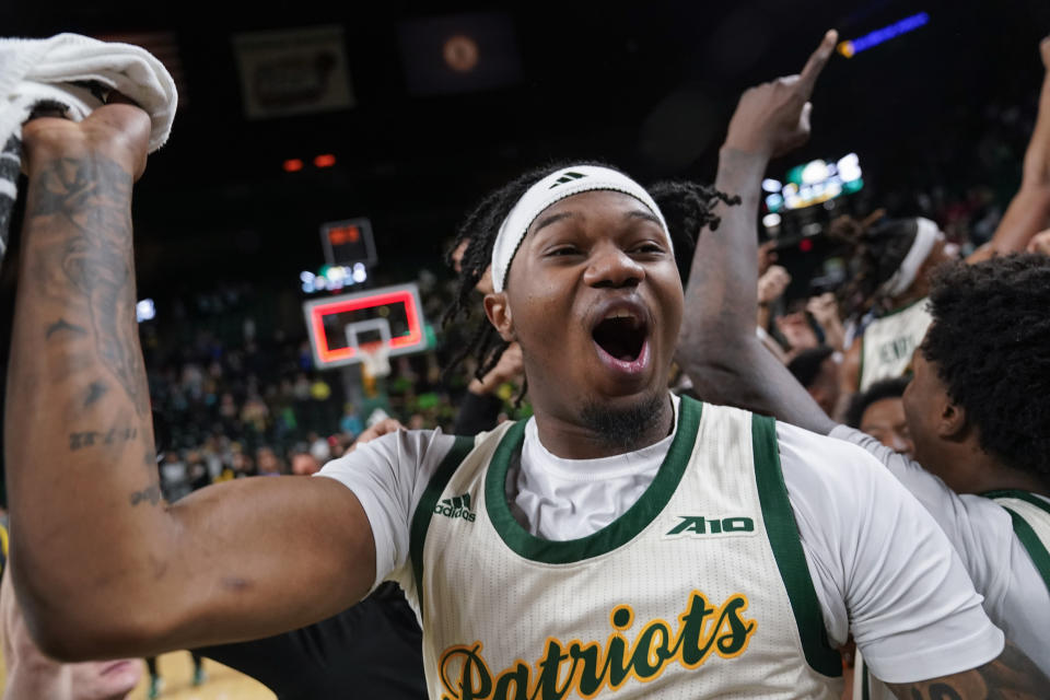 George Mason guard Woody Newton (2) celebrates as fans storm the court after an NCAA college basketball game against Dayton, Wednesday, Feb. 21, 2024, in Fairfax, Va. George Mason won 71-67. (AP Photo/Jess Rapfogel)