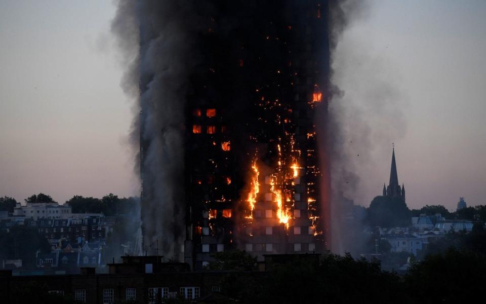 Flames and smoke billow as firefighters deal with a serious fire in a tower block at Latimer Road - Credit: Reuters