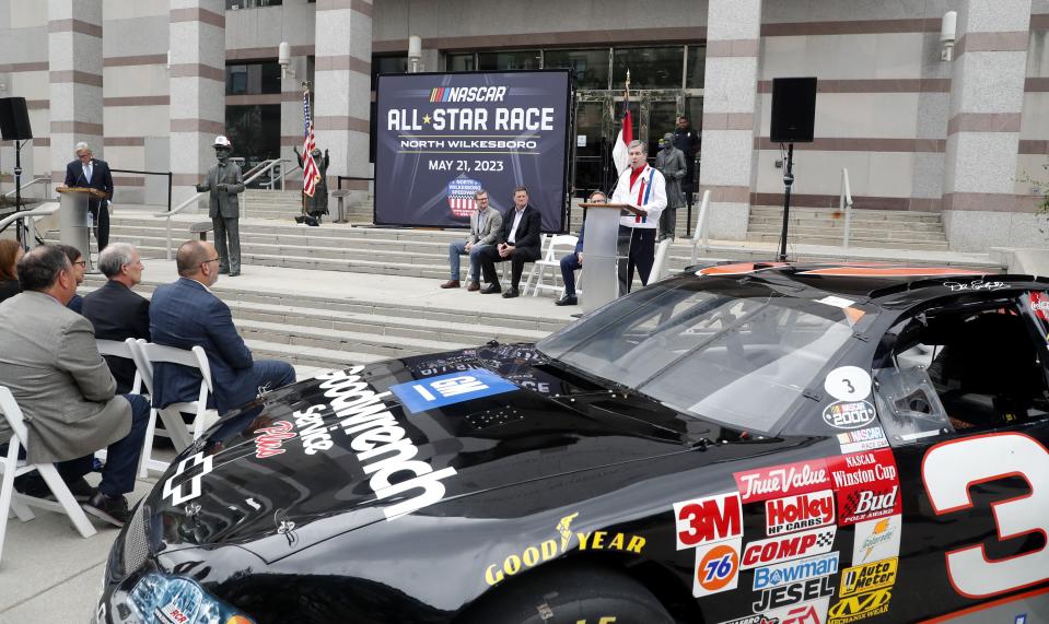 North Carolina Governor Roy Cooper speaks during a press conference announcing that the NASCAR All-Star Race will be held at North Wilkesboro Speedway in May 2023, on the steps of the N.C. Museum of History in Raleigh, N.C., Thursday, Sept. 8, 2022. Looking on, seated at centr are Dale Earnhardt Jr. and NASCAR Chief Operating Officer Steve O'Donnell, (Ethan Hyman/The News & Observer via AP)