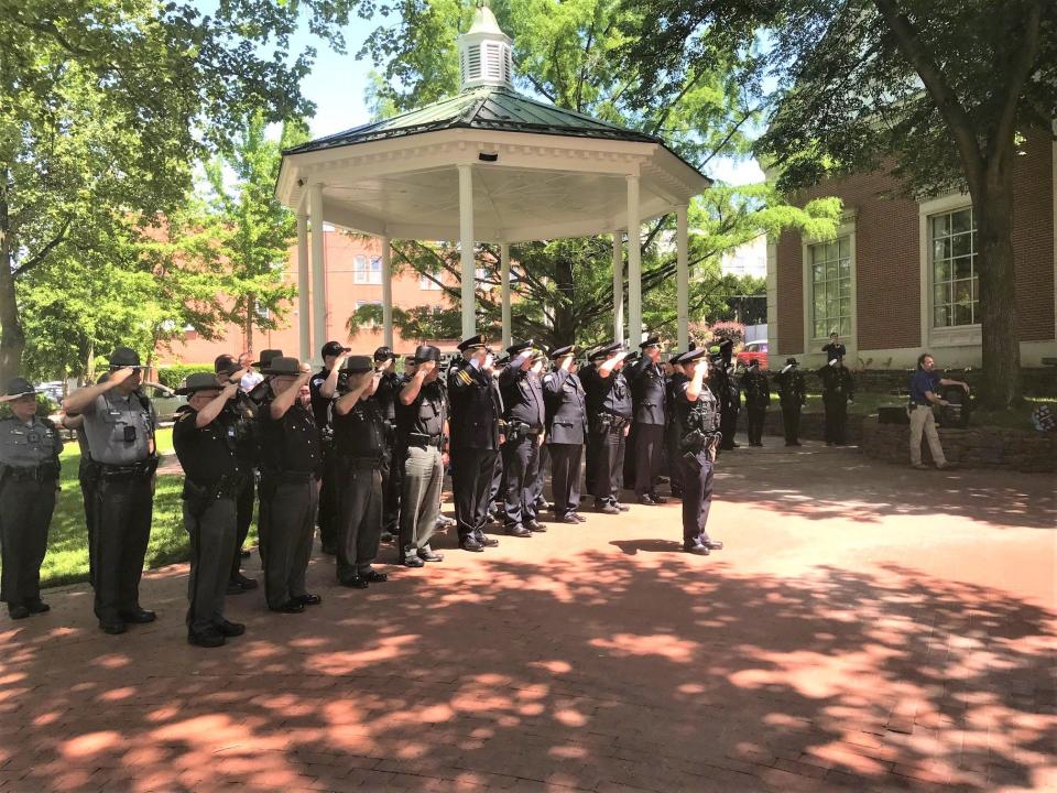 Local law enforcement officers stand at attention during the city's annual memorial service Tuesday at the downtown bandstand for fallen officers.