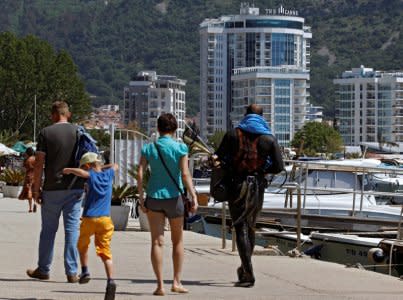 Newly-built real estates are seen behind tourists in city marina in Budva, Montenegro, May 15, 2017. Picture taken May 15, 2017. REUTERS/Stevo Vasiljevic