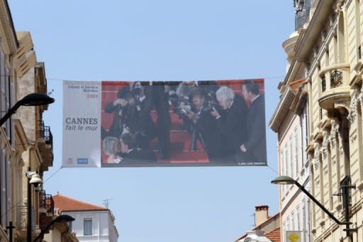 A giant photograph showing French singer and actor Johnny Hallyday kissing his wife Laetitia hangs between buildings, on May 12 in Cannes, southeastern France. Arthouse directors and Hollywood royalty will converge on the French Riviera for two weeks from Wednesday as the Cannes Film Festival rolls out the red carpet for the giants and mavericks of the movie galaxy