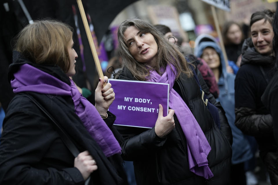 FILE - Women talk during a demonstration as part of the International Women's Day, March 8, 2023 in Paris. Women across the world will demand equal pay, reproductive rights, education, justice and other essential needs during demonstrations marking International Women’s Day on Friday, March 8, 2024. (AP Photo/Christophe Ena, File)