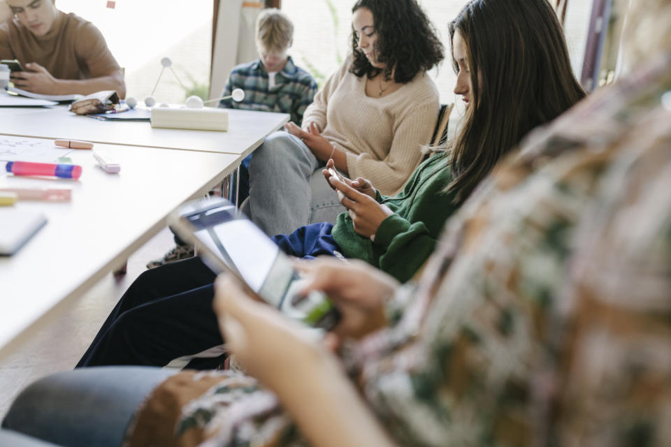 Students sitting on their phones while in class