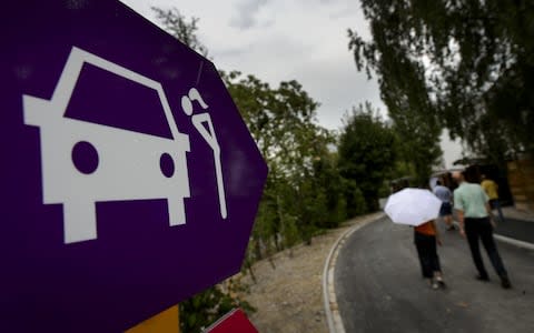 Visitors walk next to a sign on August 24, 2013 during a doors open day at a sex drive-in recently unveiled by the city of Zurich which local authorities say it will enable them to keep closer tabs on prostitution - Credit: AFP