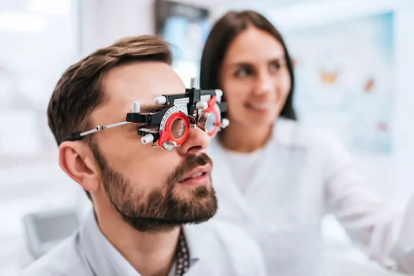 female doctor  ophthalmologist is checking the eye vision of handsome young man in modern clinic. Doctor and patient in ophthalmology clinic.