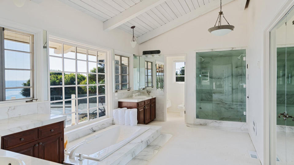 The luxe bathroom with marble detailing and a glass-door shower. - Credit: Chris Cortazzo