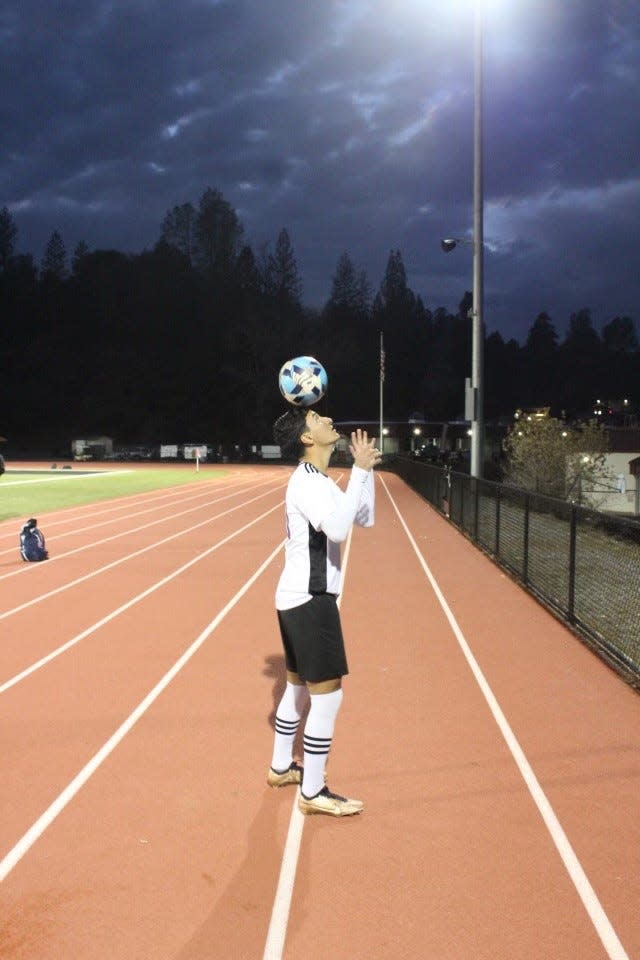 Escalon senior forward Luis Flores balances a soccer ball on his head during a game in the 2022-23 season.
