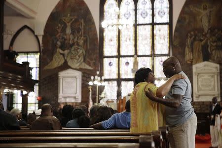 Parishioners embrace before services at the Emanuel African Methodist Episcopal Church in Charleston, South Carolina, in this June 21, 2015, file photo. REUTERS/David Goldman/Pool
