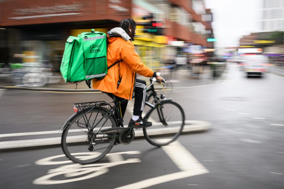 A delivery rider travels through the Hammersmith region on February 14, 2024, in London, England.