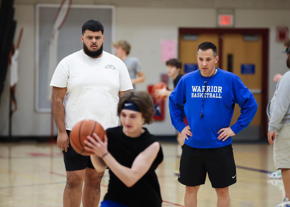 Winnacunnet High School boys basketball head coach Jay McKenna, right, and assistant coach Seth Provencher oversee a shooting drill during Tuesday's practice.