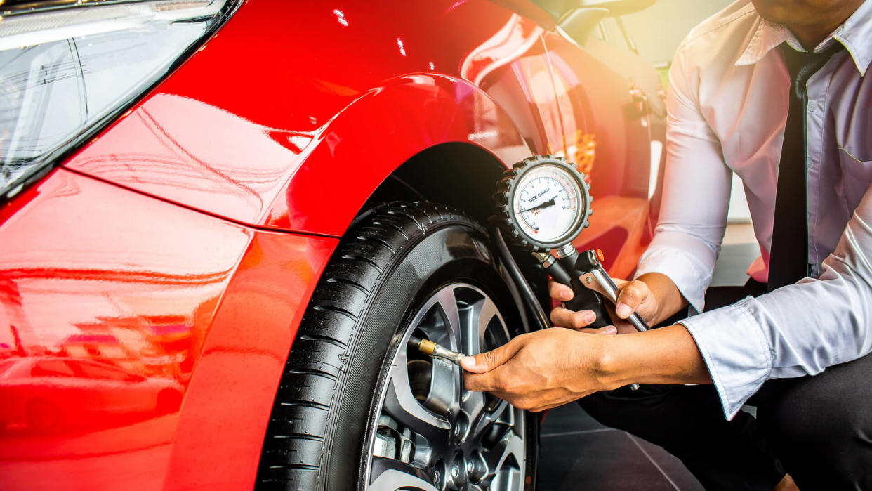 Asian man car inspection Measure quantity Inflated Rubber tires car.