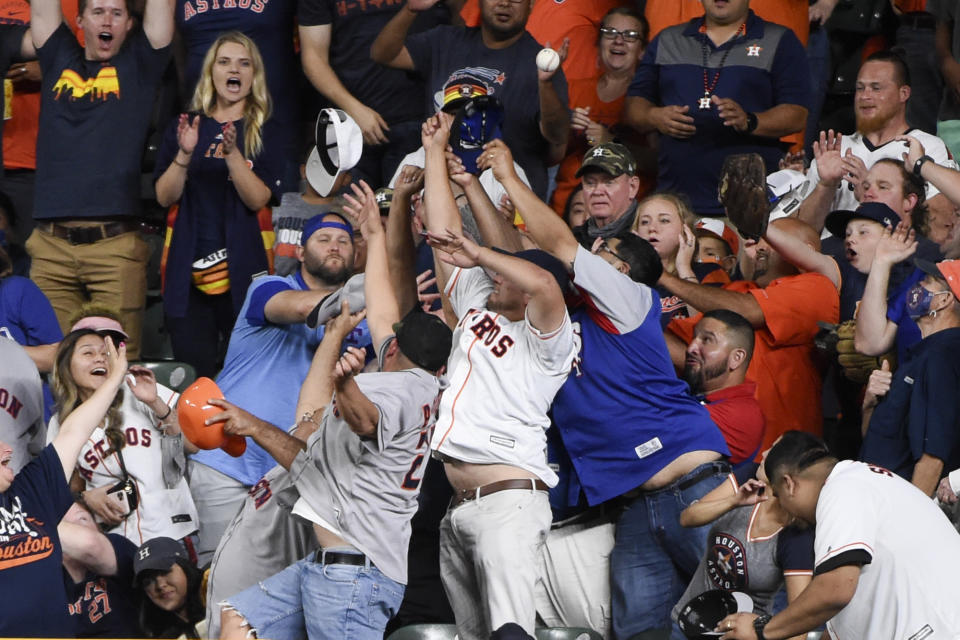 Fans try to catch the home run ball of Houston Astros' Kyle Tucker during the seventh inning of a baseball game against the Texas Rangers, Saturday, May 15, 2021, in Houston. (AP Photo/Eric Christian Smith)