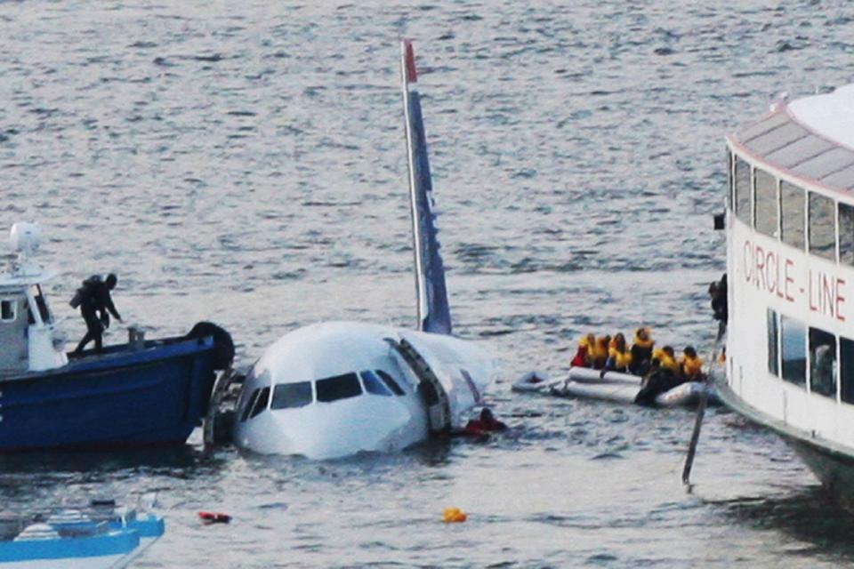 FILE - In this Jan. 15, 2009 file photo, a diver, left, aboard an NYPD vessel prepares to rescue passengers that escaped from the Airbus 320 US Airways aircraft made an emergency landing in the Hudson River in New York in what came to be known as the "Miracle on the Hudson" because everyone survived. It's been 10 years since US Airways flight 1549 landed on the Hudson River after colliding with a flock of geese just after takeoff. (AP Photo/Bebeto Matthews, File) ORG XMIT: NYR101